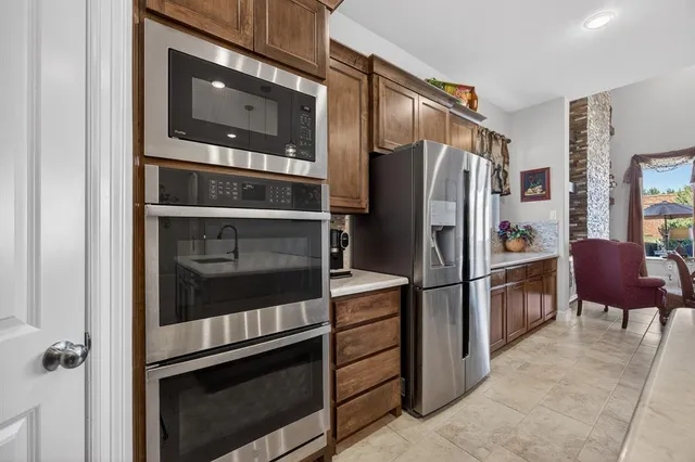 a kitchen with a refrigerator stove and chairs