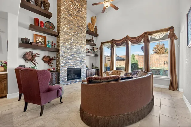 a living room with furniture a fireplace and a large window