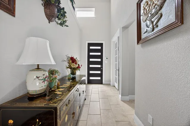 a view of a hallway to room with wooden floor and cabinet
