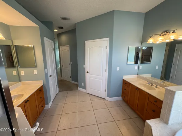 a bathroom with a double vanity sink mirror and bathtub