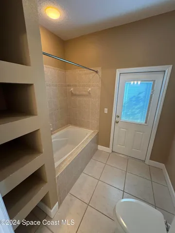 a view of a swimming pool with a yard and wooden fence