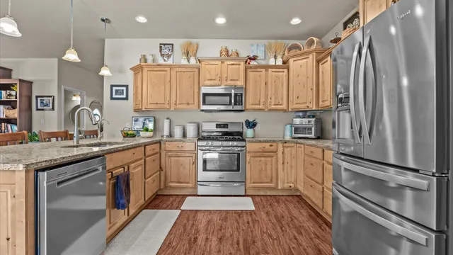 a kitchen with stainless steel appliances granite countertop a stove top oven a sink and cabinets