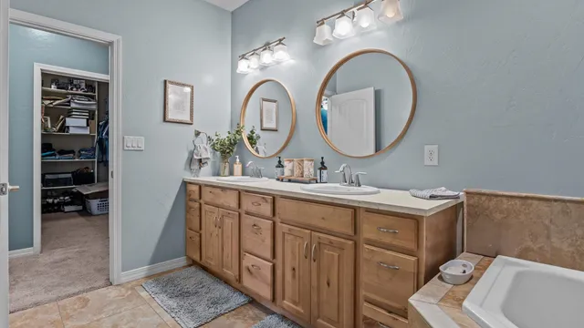 a bathroom with a granite countertop double vanity sink and a mirror