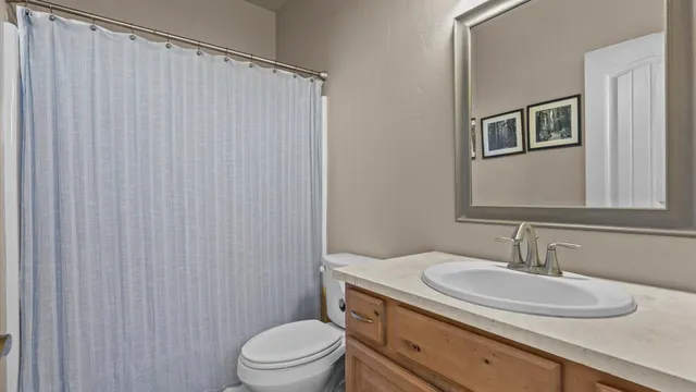 a bathroom with a granite countertop sink toilet and a mirror
