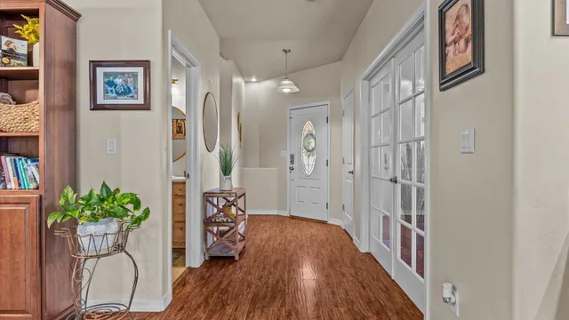 a hallway with wooden floor and a potted plant