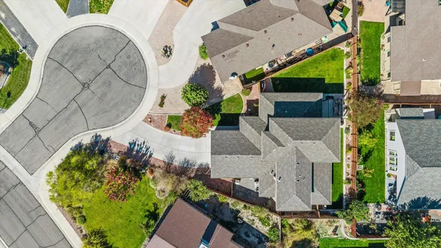 an aerial view of a house with a yard and a large tree