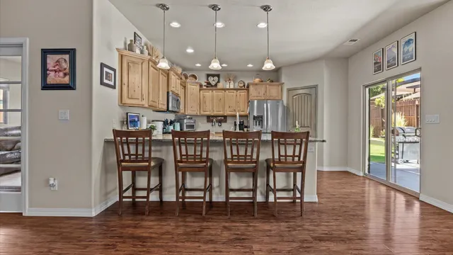 a dining room with furniture a chandelier and wooden floor