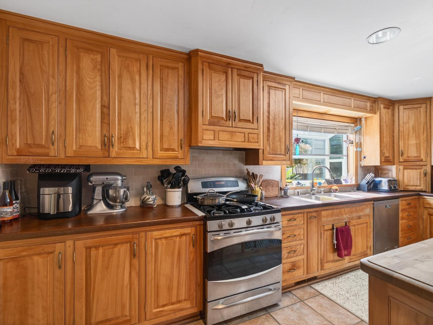 209 Hames Road Watsonville, CA 95076 - Photo 21 of 60 a kitchen with stainless steel appliances granite countertop a stove a sink dishwasher and cabinets with wooden floor