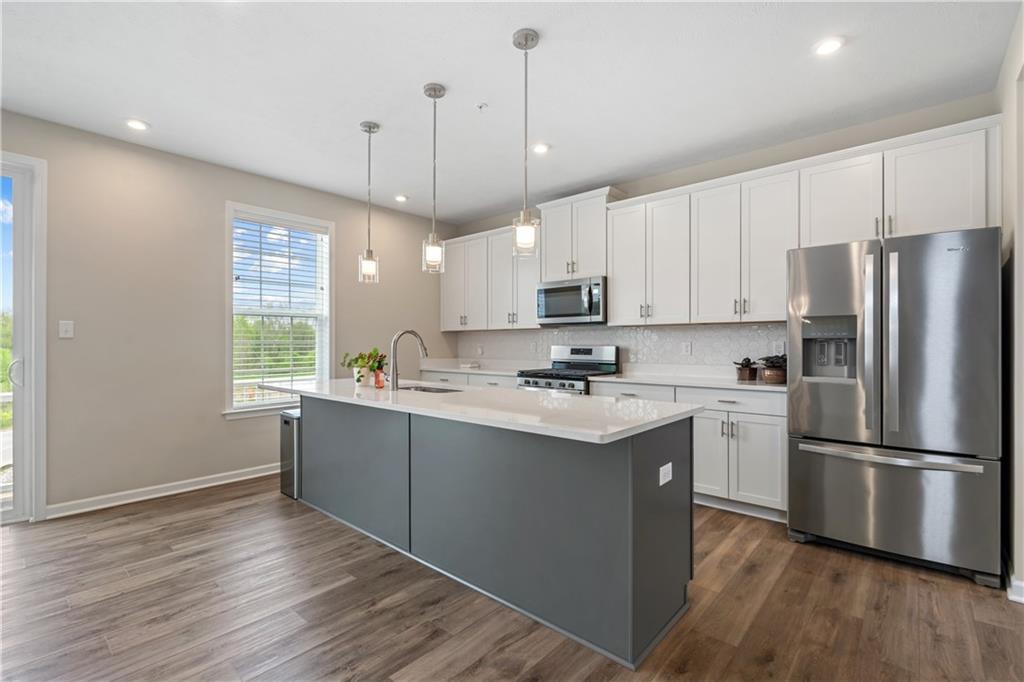 107 Affinity Drive Harmony, PA 16037 - Photo 15 of 49 a kitchen with stainless steel appliances granite countertop a refrigerator a sink dishwasher a stove and white cabinets with wooden floor