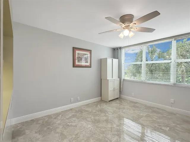 a view of a livingroom with a ceiling fan and window