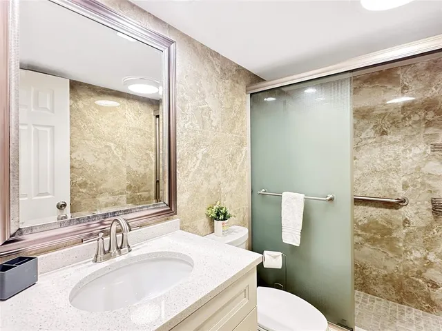 a bathroom with a sink toilet and shower