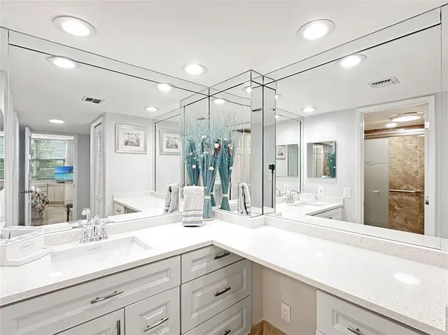 a bathroom with double vanity and a mirror