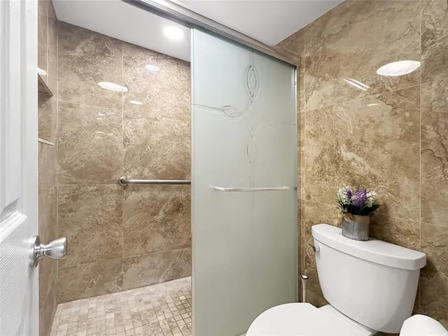 a white toilet sitting next to a bathroom sink