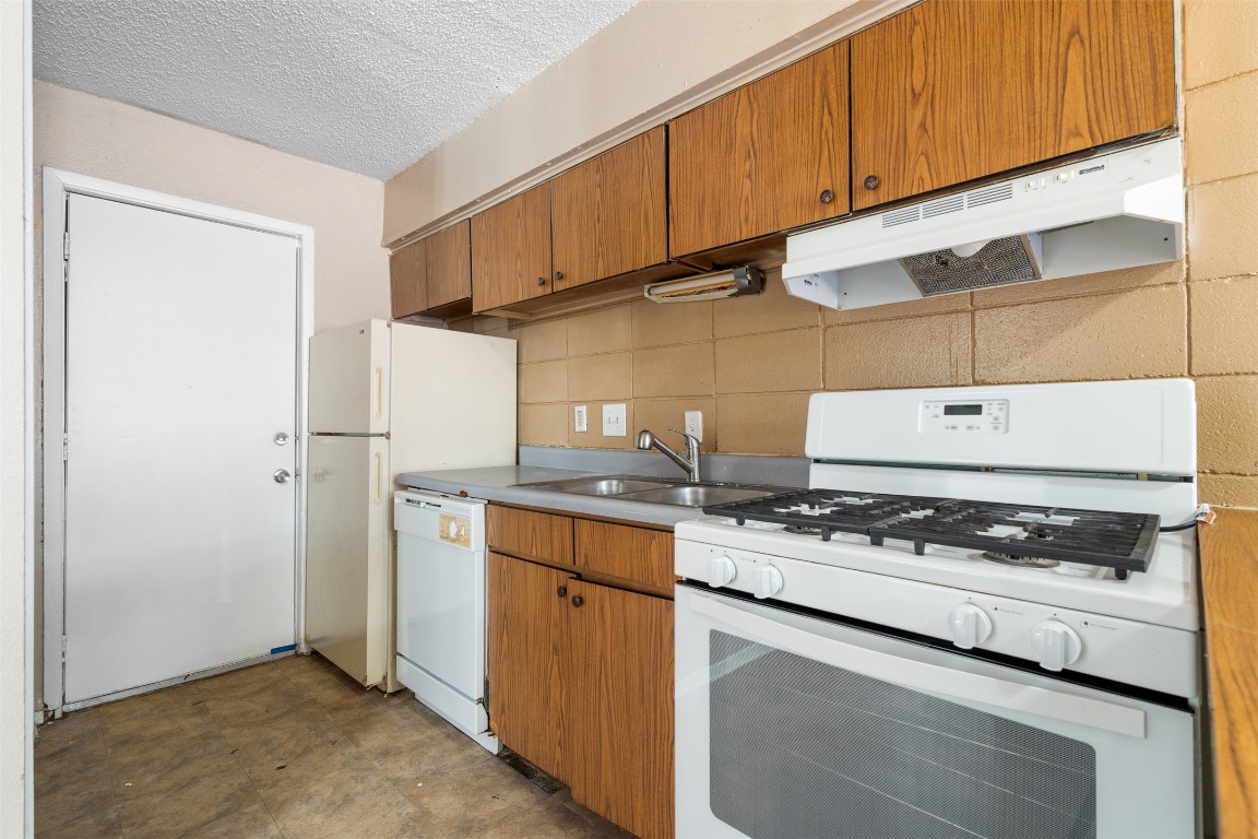 311 East 31st Street, Unit 107 Austin, TX 78705 - Photo 9 of 21 a kitchen with stainless steel appliances granite countertop a stove and a refrigerator