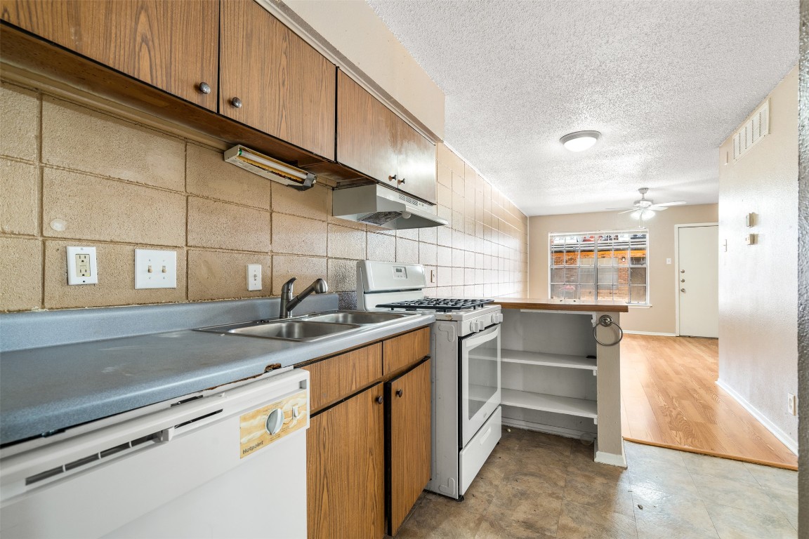 311 East 31st Street, Unit 107 Austin, TX 78705 - Photo 10 of 21 a kitchen with stainless steel appliances granite countertop a sink and cabinets