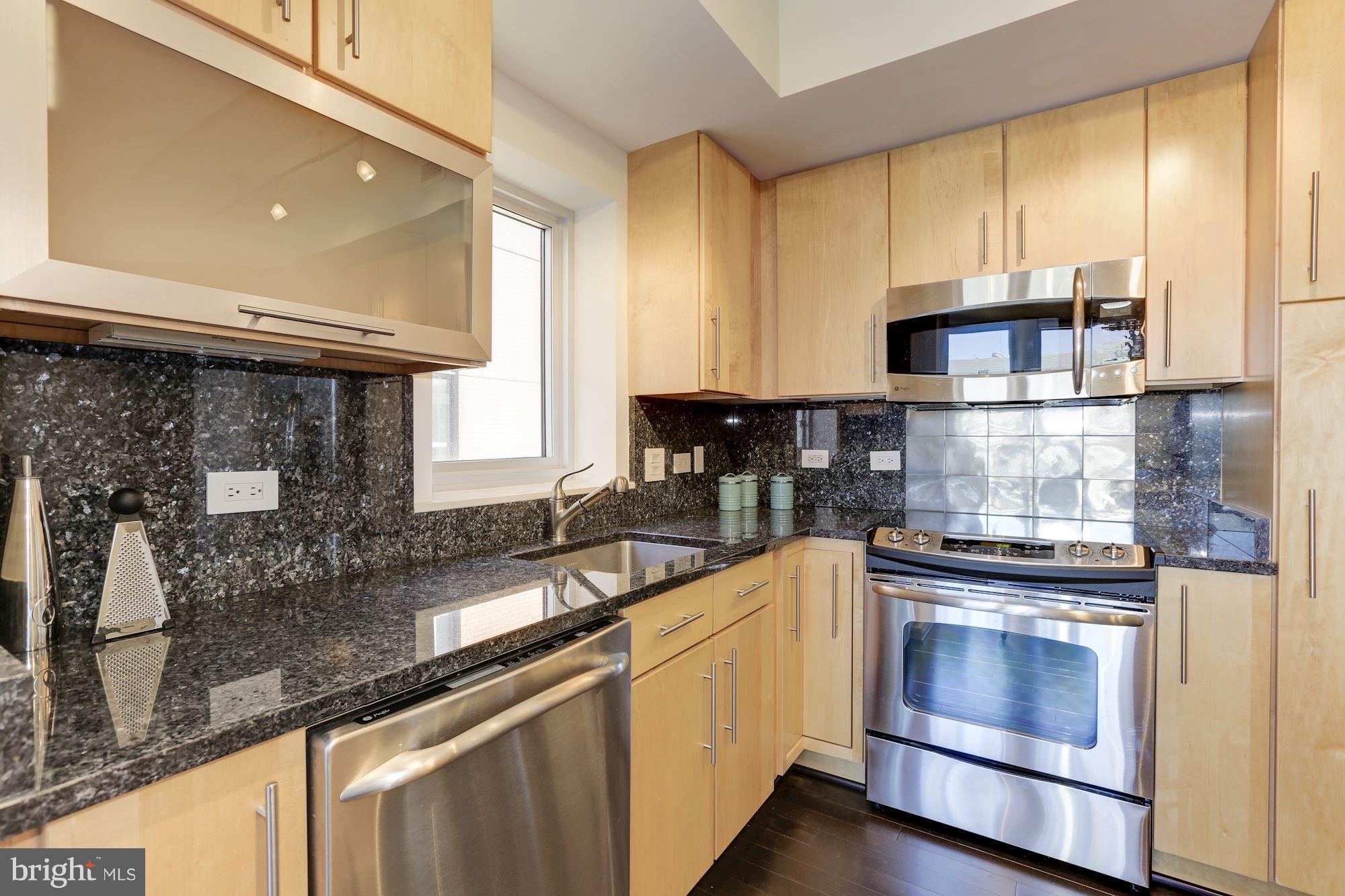 1025 First Street Southeast, Unit 916 Washington, DC 20003 - Photo 11 of 30 a kitchen with granite countertop a sink stainless steel appliances and cabinets