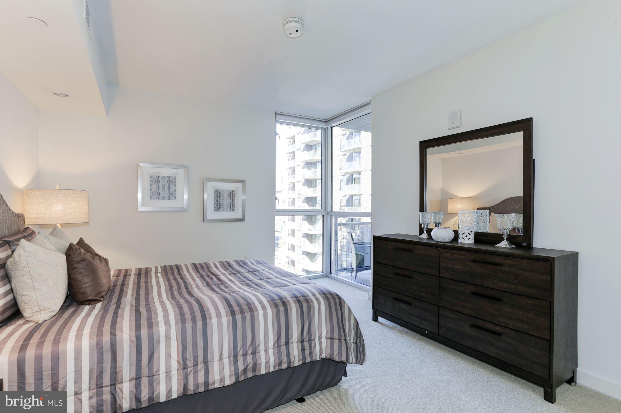 1025 First Street Southeast, Unit 916 Washington, DC 20003 - Photo 19 of 30 a bedroom with a bed and window with lamp