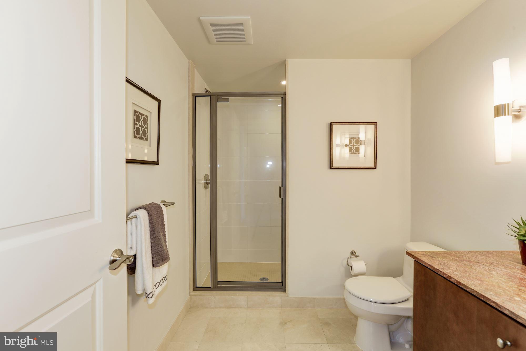 1025 First Street Southeast, Unit 916 Washington, DC 20003 - Photo 22 of 30 a bathroom with a sink a toilet and shower