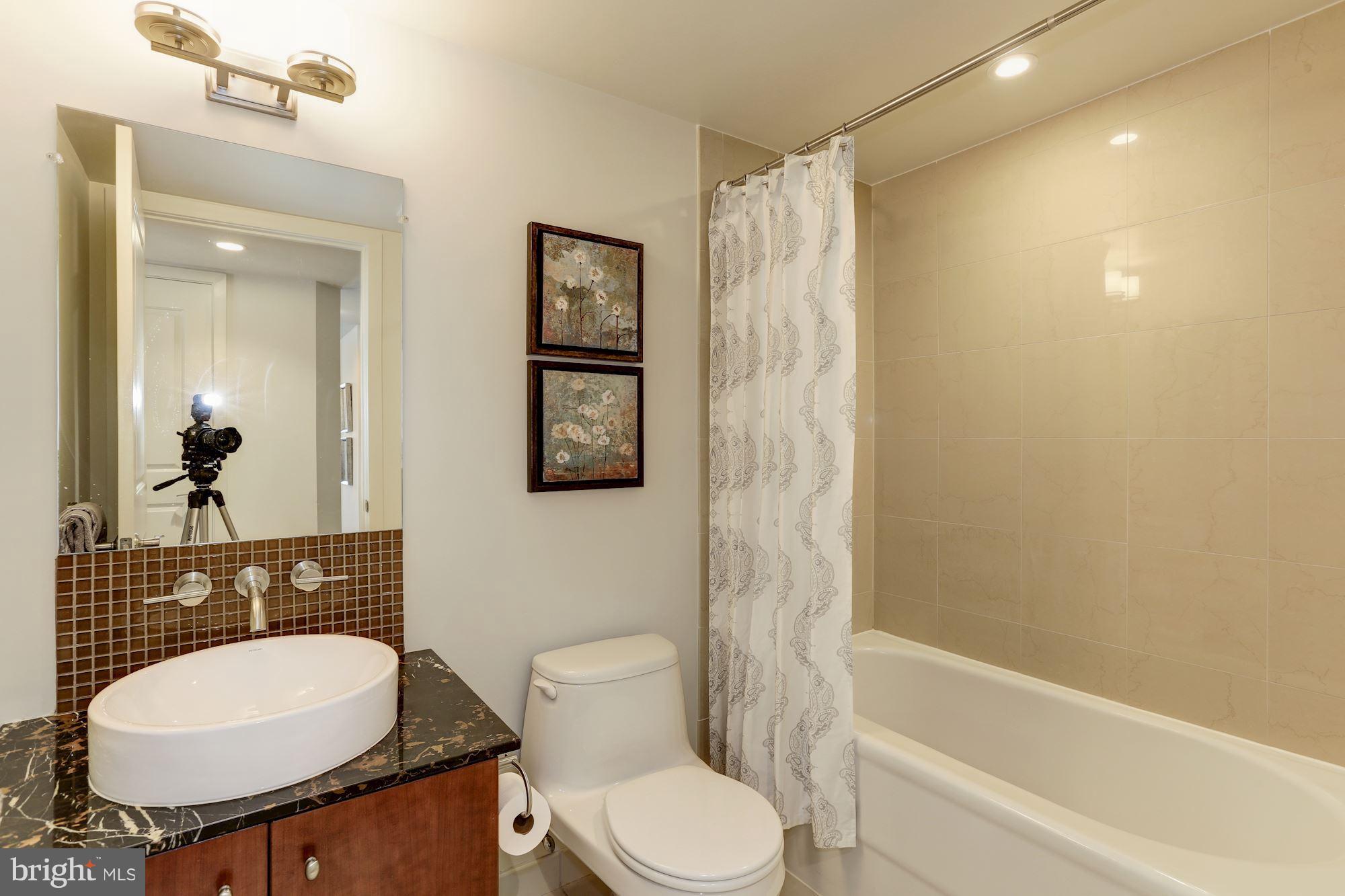 1025 First Street Southeast, Unit 916 Washington, DC 20003 - Photo 5 of 30 a bathroom with a toilet a sink and mirror