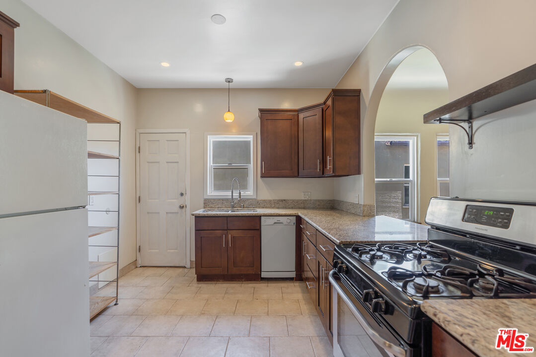 458 North Genesee Avenue Los Angeles, CA 90036 - Photo 12 of 38 a kitchen with stainless steel appliances granite countertop a stove a sink and a refrigerator