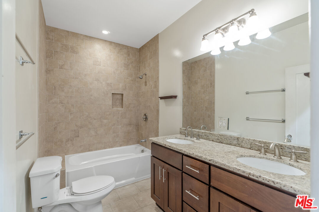 458 North Genesee Avenue Los Angeles, CA 90036 - Photo 18 of 38 a bathroom with a granite countertop bathtub shower sink vanity mirror and toilet