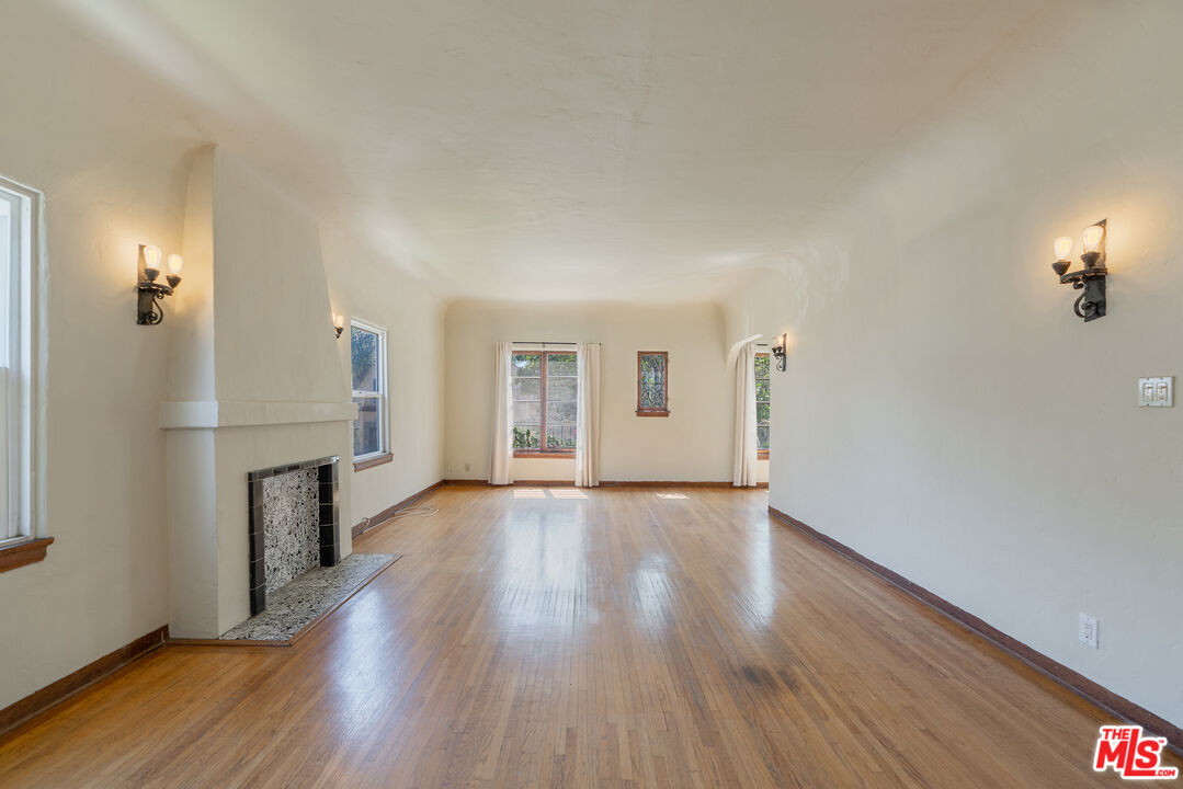 458 North Genesee Avenue Los Angeles, CA 90036 - Photo 4 of 38 an empty room with wooden floor fireplace and windows