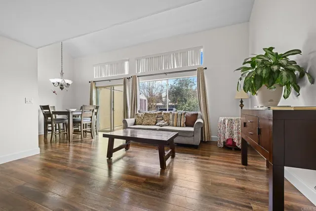 a living room with furniture a large window and a wooden floor