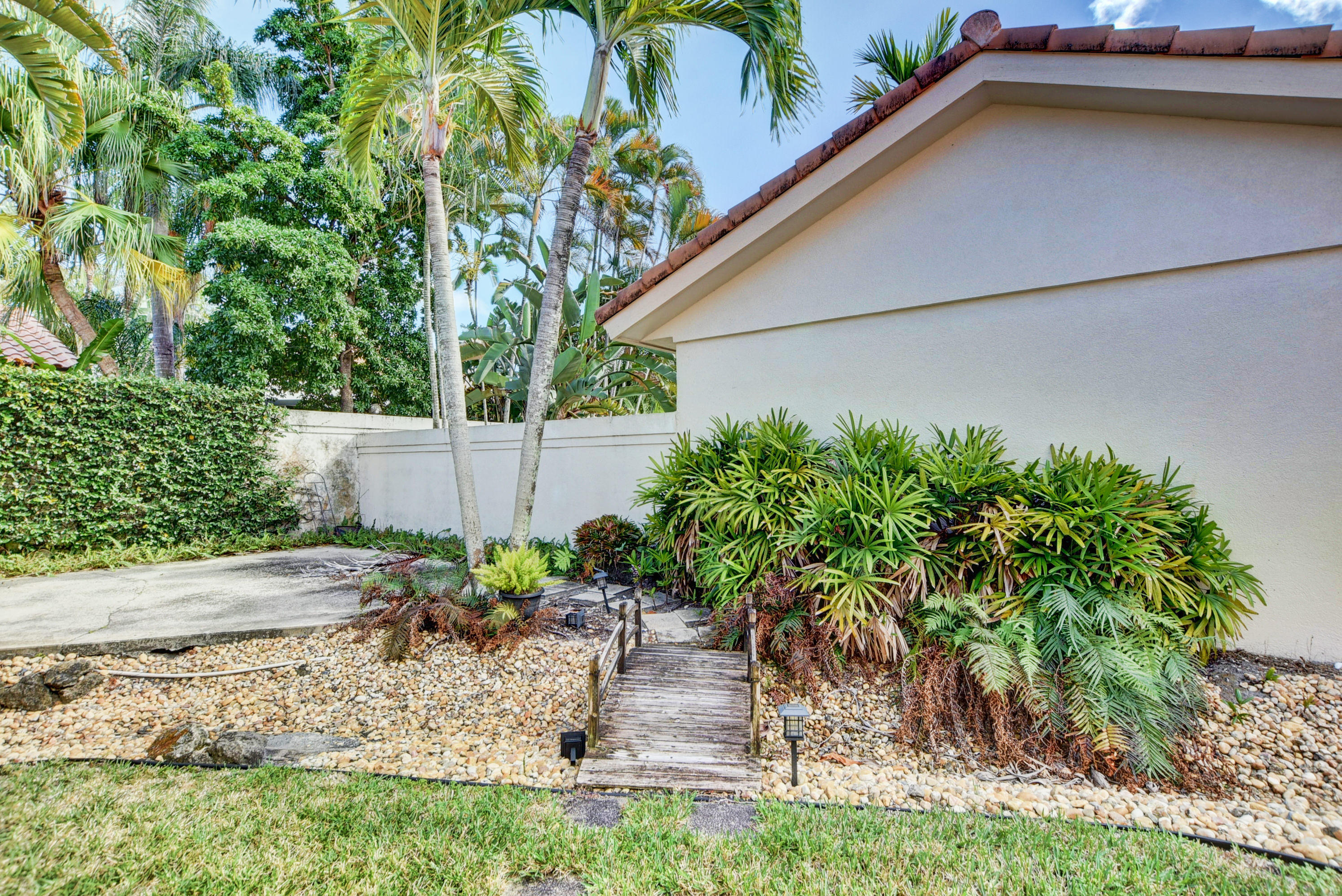 2602 Mohawk Circle West Palm Beach, FL 33409 - Photo 29 of 39 a backyard of a house with plants and outdoor seating