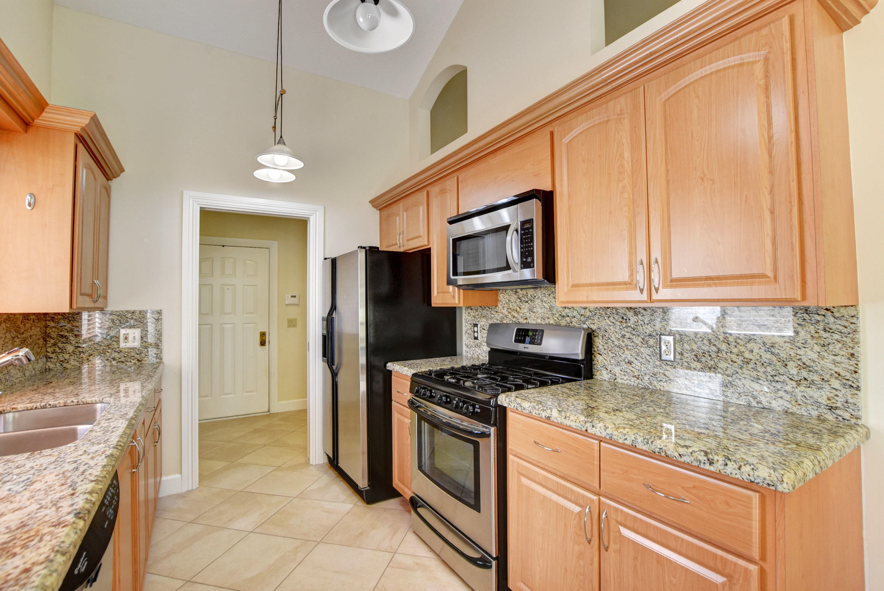 2602 Mohawk Circle West Palm Beach, FL 33409 - Photo 5 of 39 a kitchen with stainless steel appliances granite countertop a stove a sink and a refrigerator
