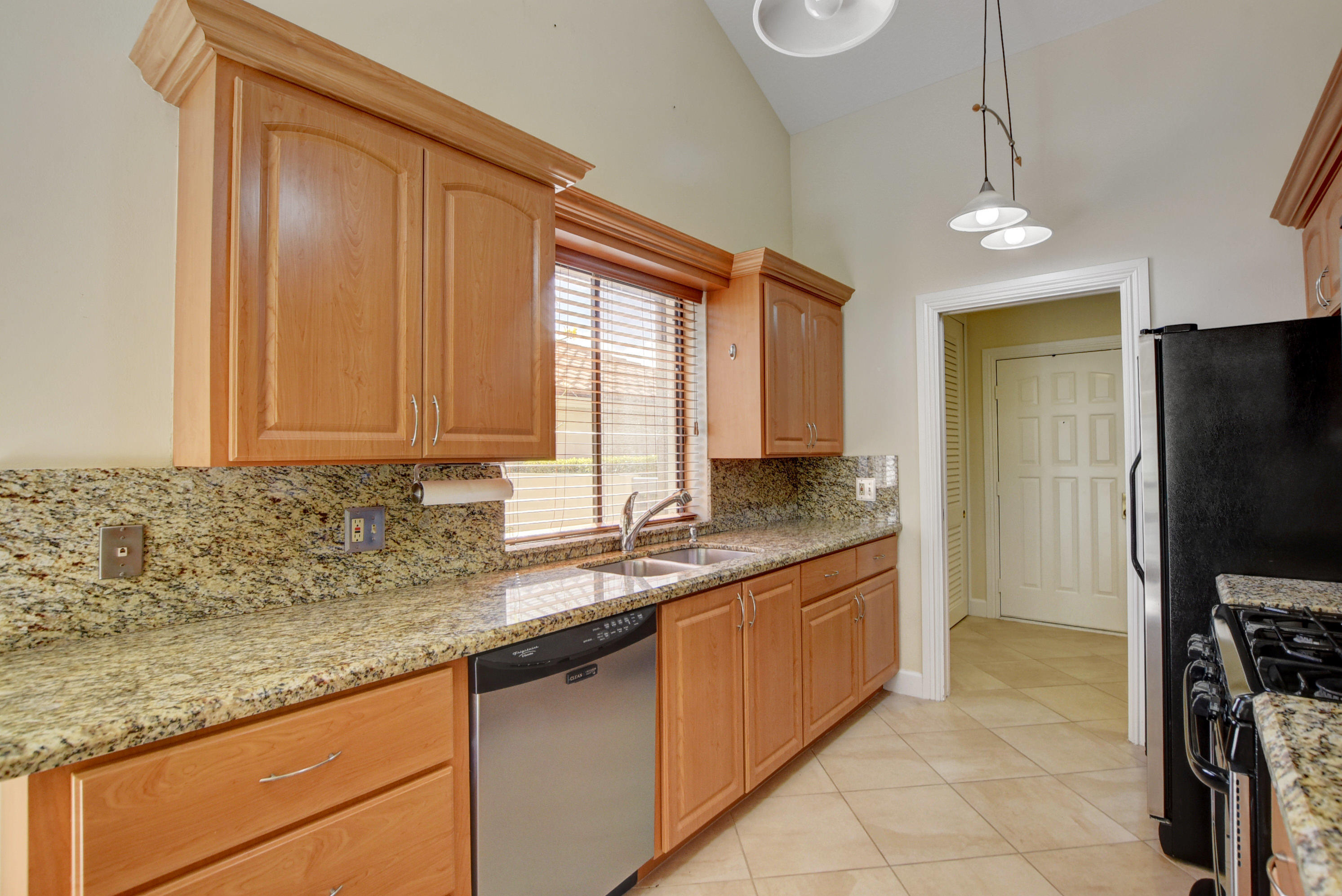 2602 Mohawk Circle West Palm Beach, FL 33409 - Photo 6 of 39 a kitchen with stainless steel appliances granite countertop a sink a stove and a microwave