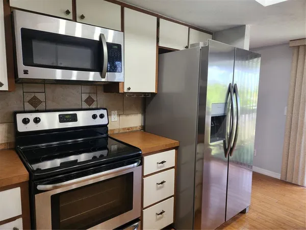 a kitchen with stainless steel appliances granite countertop a sink refrigerator and cabinets