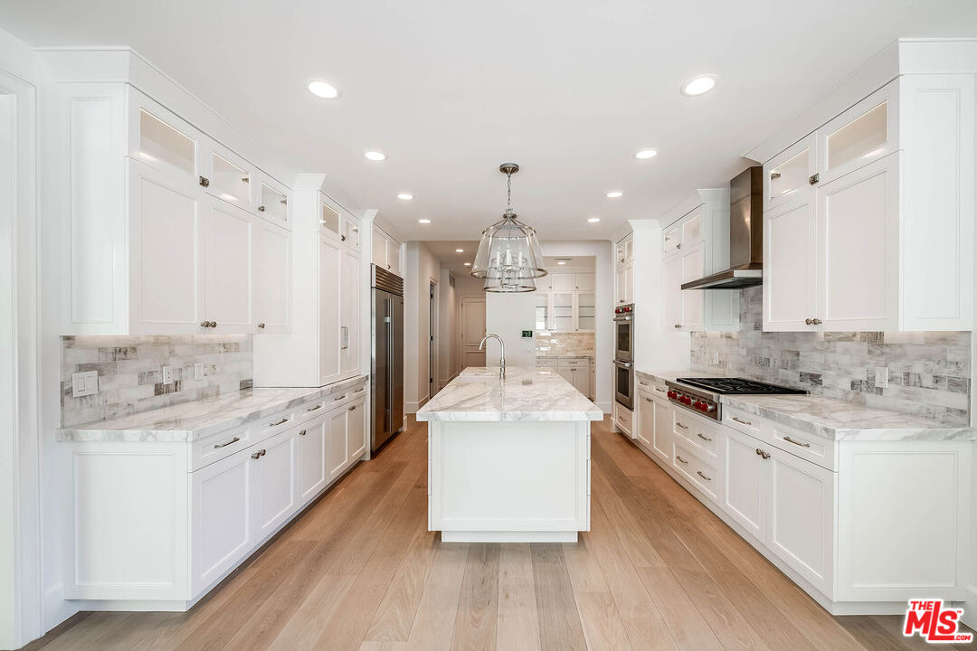 1348 Marinette Road Pacific Palisades, CA 90272 - Photo 15 of 50 a large white kitchen with a stove top oven a sink a refrigerator and white cabinets