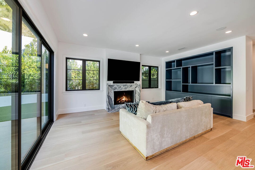1348 Marinette Road Pacific Palisades, CA 90272 - Photo 17 of 50 a living room with furniture a fireplace and a flat screen tv