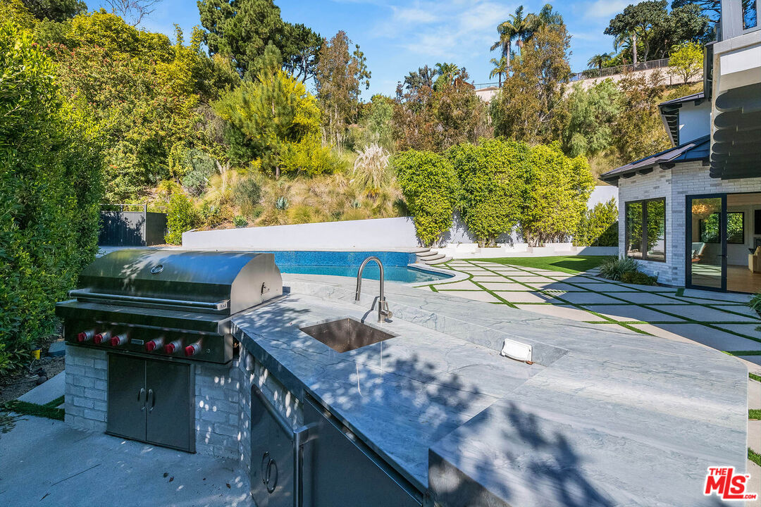 1348 Marinette Road Pacific Palisades, CA 90272 - Photo 23 of 50 a view of a patio with table and chairs with wooden fence