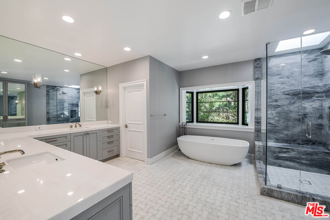 1348 Marinette Road Pacific Palisades, CA 90272 - Photo 36 of 50 a bathroom with a granite countertop tub a sink and a shower