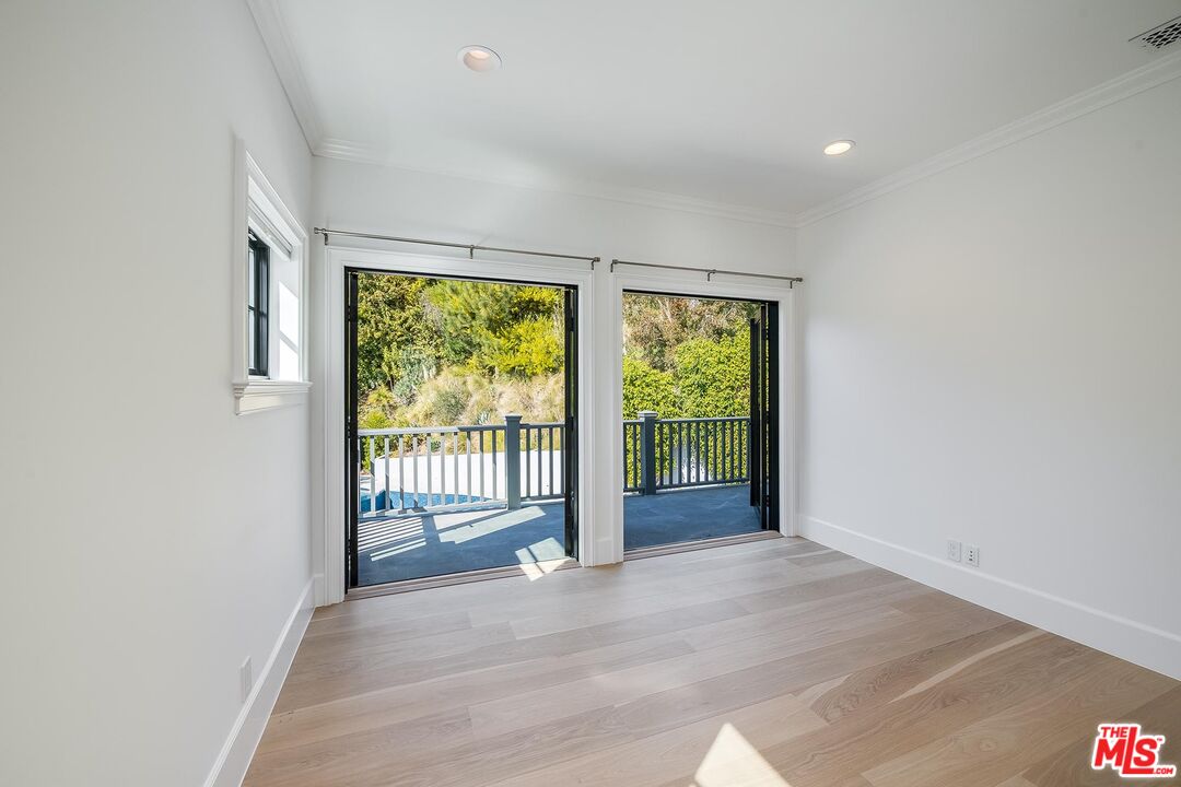 1348 Marinette Road Pacific Palisades, CA 90272 - Photo 46 of 50 an empty room with wooden floor and a floor to ceiling window
