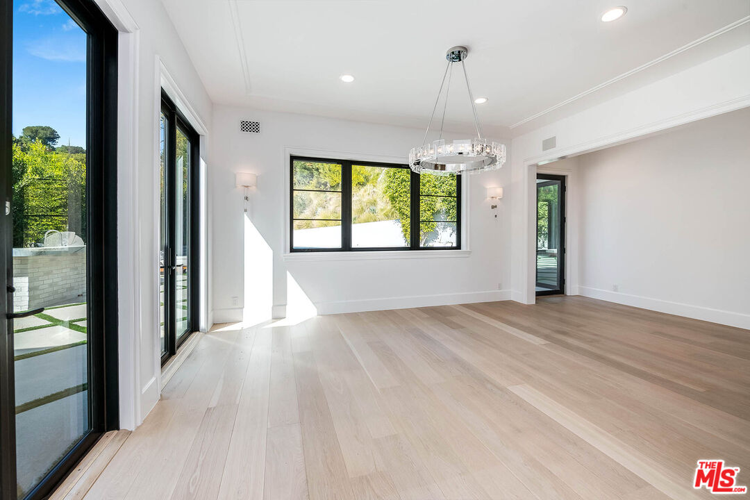 1348 Marinette Road Pacific Palisades, CA 90272 - Photo 9 of 50 a view of an empty room with a window and wooden floor