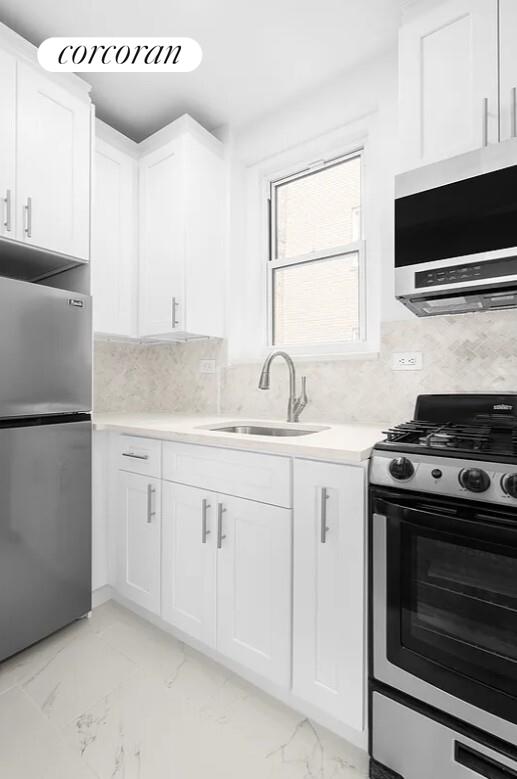 210 West 19th Street, Unit 4J Manhattan, NY 10011 - Photo 11 of 13 a kitchen with granite countertop a sink stainless steel appliances and cabinets