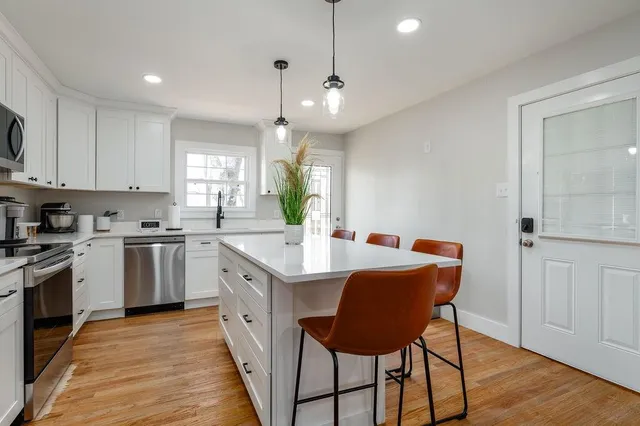 a kitchen with granite countertop a sink a counter space appliances and cabinets