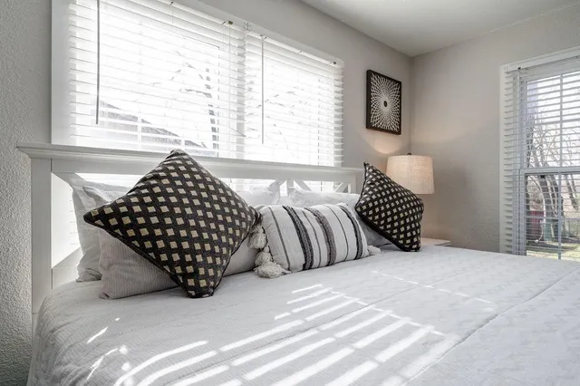 a bedroom with a bed and a large window