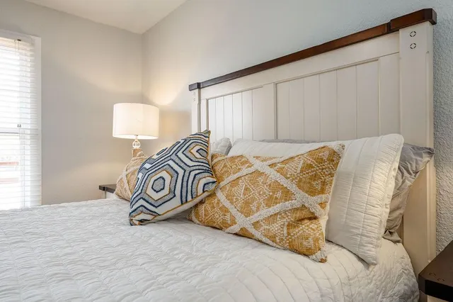 a view of a bedroom with bed and a window