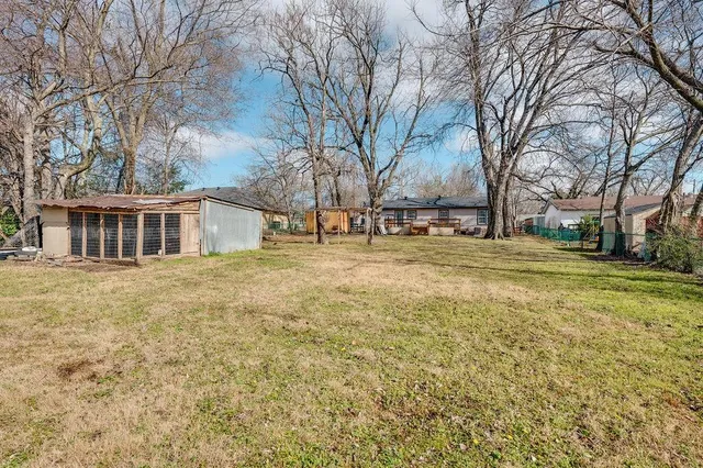 a backyard of a house with large trees and outdoor space
