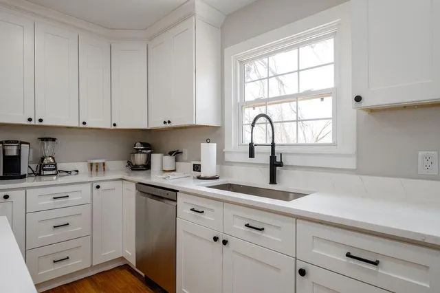 a kitchen with cabinets appliances a sink and a window