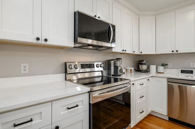 a kitchen with white cabinets and stainless steel appliances