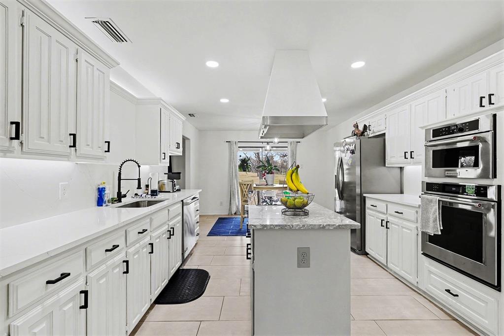 6746 Talbot Parkway Dallas, TX 75232 - Photo 12 of 34 a kitchen that has a lot of white cabinets and stainless steel appliances