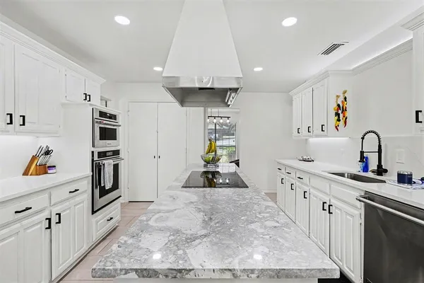 a kitchen with white cabinets and sink