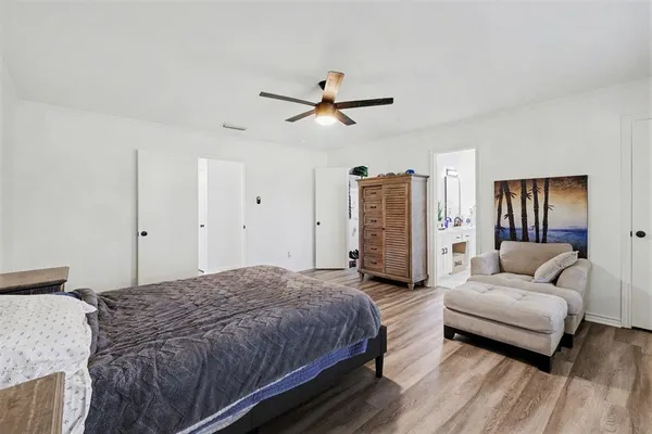 a spacious bedroom with a bed couch and a ceiling fan