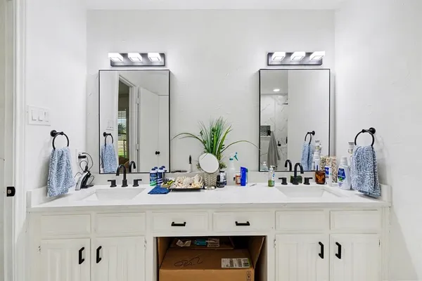 a bathroom with double vanity sink and a mirror