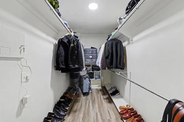a view of walk in closet with clothes and shoes