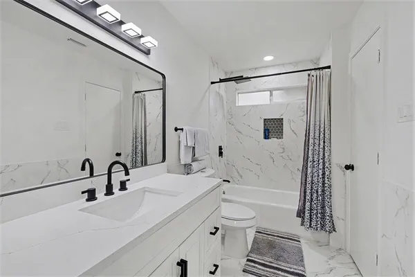a bathroom with a sink a toilet and shower